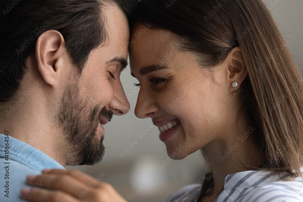 Warmth in relationship. Affectionate couple in love embrace close to one another touch foreheads enjoy intimate moment. Bonding lovers soulmates hug express tender feeling. Close up side view portrait Warmth in relationship. Affectionate couple in love embrace close to one another touch foreheads enjoy intimate moment. Bonding lovers soulmates hug express tender feeling. Close up side view portrait