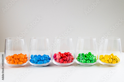 M&M's candy in the glasses, colorful candy, multicolored gradient