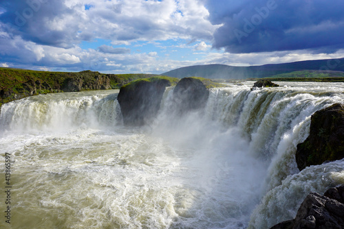 godafoss waterfall, beautiful clouds are in the sky, splashes of water rise into the sky, nature of Iceland