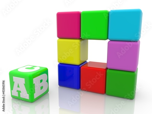 Green toy block with ABC letters next to colored toy blocks