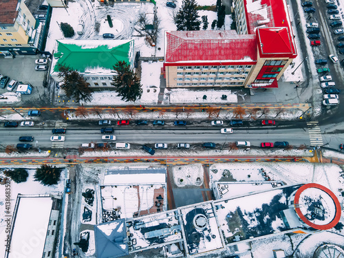Aerial top down view of road in small european city with snow covered roofs