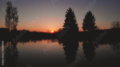 Sunrise Reflecting In Glassily Pond Water Then Flight over Fields photo