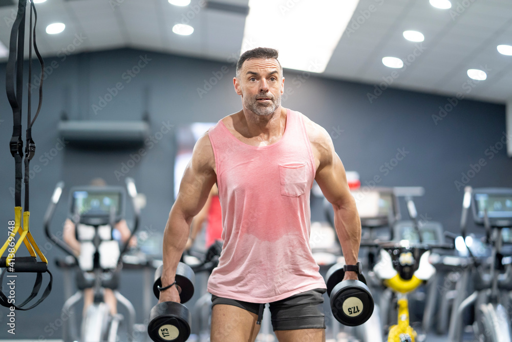 Very strong man lifting weights in gym. Very strong man lifting weights in gym.