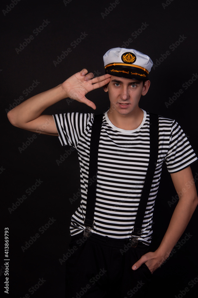 Fototapeta premium Handsome guy on a black background. Captain of a sea vessel. Positive and negative emotions.