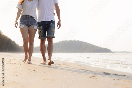 Close up couple walking on beach together. Romantic beach vacation.