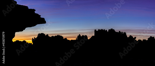 panorama view of the strange karst rock formations in El Torcal Nature Reserve in silhouette at sunset