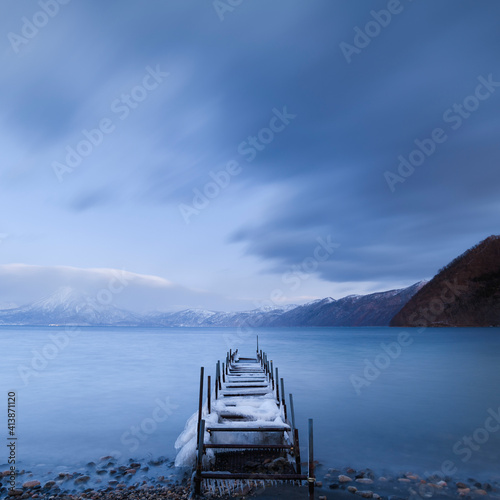 Long exposure shot of boat pier covered in ice at lake Shikotsu, Hokkaido, Japan photo