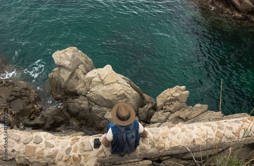 Adventurous man with photo camera and binoculars exploring a roc photo