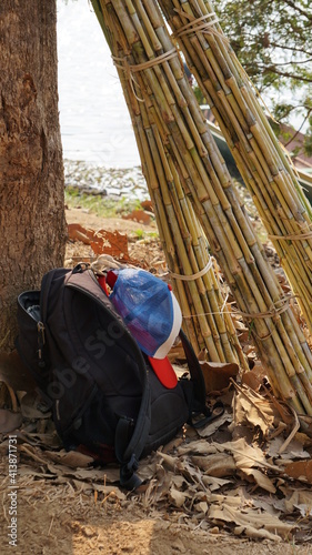 a backpack and a cap next to some sugar cane at the Nam Tien Lake in Sayaboury, Laos, February photo