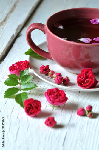 Obraz na płótnie cup of tea and rose flowers and buds on white wood w salonie