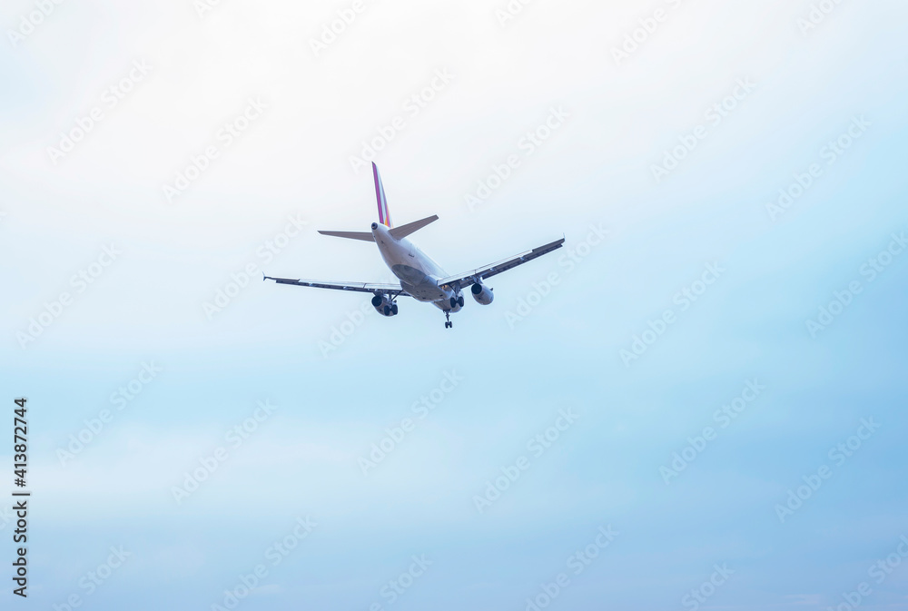 Low angle view of commercial airplane flying in sky with landing gear ready to take off at airport Low angle view of commercial airplane flying in sky with landing gear ready to take off at airport