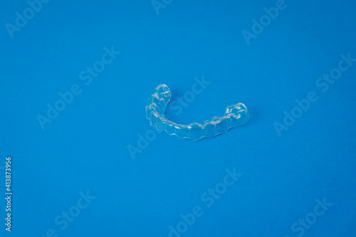 View of a transparent plastic dental appliance on a blue background