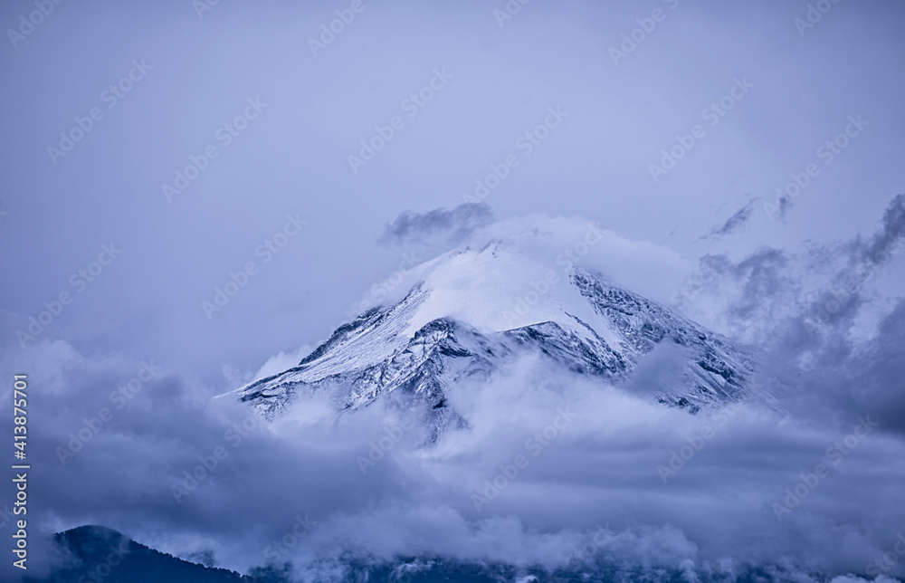 Inactive volcano peeking over the clouds at dawn Inactive volcano peeking over the clouds at dawn