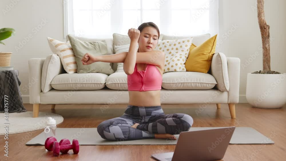Sporty woman doing yoga and exercise at home, workout training online with coach on laptop in living room Sporty woman doing yoga and exercise at home, workout training online with coach on laptop in living room