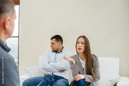 A young married couple of men and women talk to a psychologist at a therapy session. Psychology.