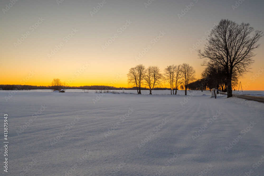 Winter rural landscape, snow covered field during sunset Winter rural landscape, snow covered field during sunset