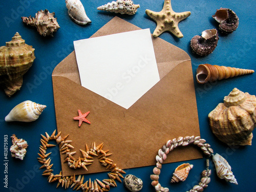 postcard mockup. blank white card with kraft brown paper envelope and seashells 