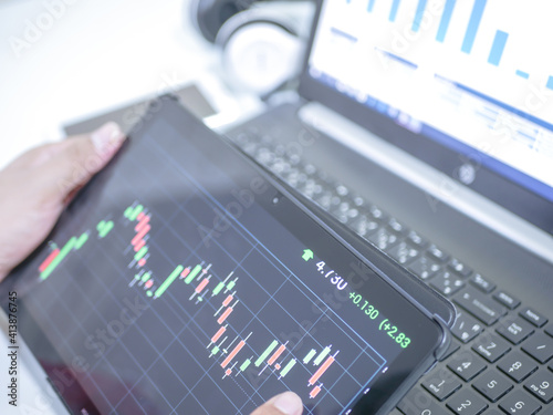 Businessman checking stock market dataมStock Market Application for Mobile, Analyzing Data Stock Market on Mobile Young Businessman with Smartphone and Stock Market Chart Background.