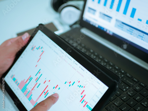 Businessman checking stock market dataมStock Market Application for Mobile, Analyzing Data Stock Market on Mobile Young Businessman with Smartphone and Stock Market Chart Background.