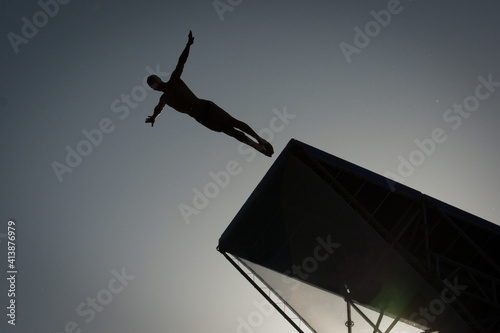 Obraz na plátne Silhouette man jump high diving