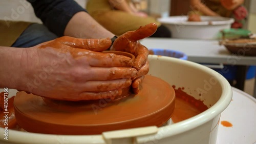 On a potter's wheel, a bowl rotates, which was molded by the hands of a potter