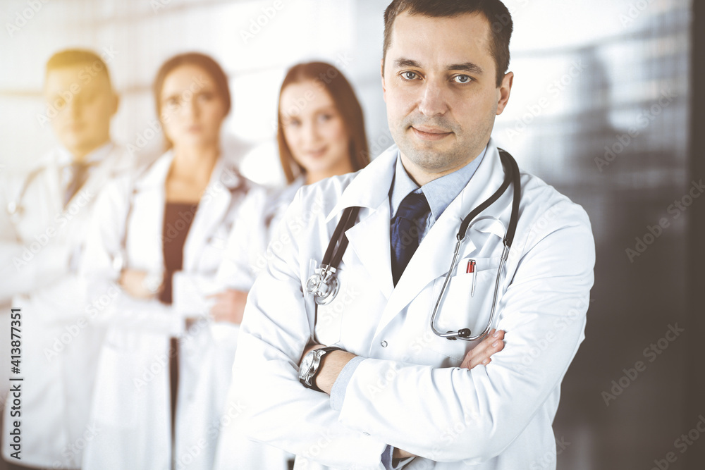 Group of professional doctors, standing as a team with crossed arms in a sunny hospital office, ready to help their patients. Best medical help, insurance in health care and medicine concept Group of professional doctors, standing as a team with crossed arms in a sunny hospital office, ready to help their patients. Best medical help, insurance in health care and medicine concept