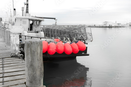 Fishing boat with bright pink buoys tied to stern rail at pier in Riverton © Brian Scantlebury