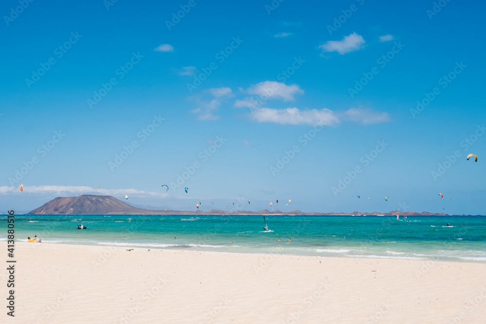 Landscape of a paradisiacal beach with yellow sand and kite surfers Landscape of a paradisiacal beach with yellow sand and kite surfers