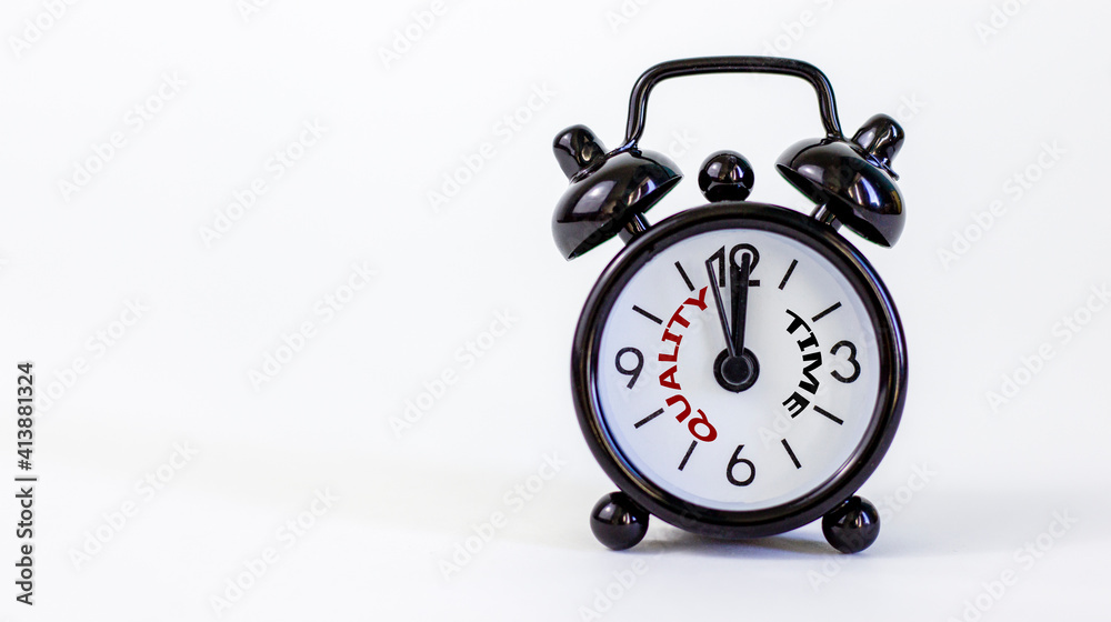 Quality time symbol. Beautiful black alarm clock with words 'quality time'. Beautiful white background. Copy space. Business and quality time concept. Quality time symbol. Beautiful black alarm clock with words 'quality time'. Beautiful white background. Copy space. Business and quality time concept.