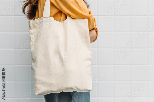 Woman is holding tote bag canvas fabric for mockup blank template. photo
