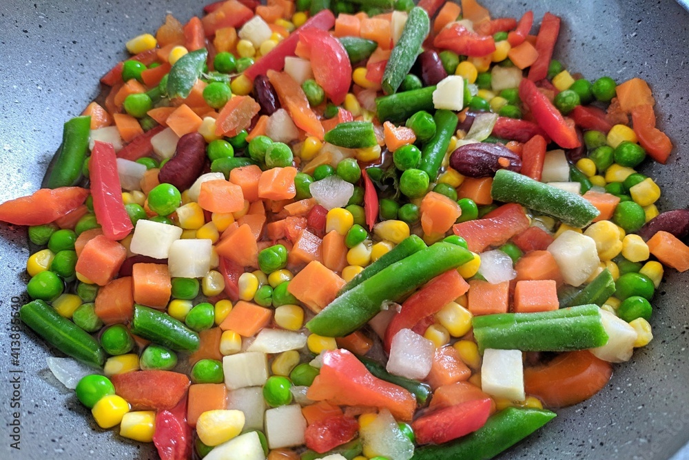 Vegetables frozen in pan for stew. Fresh vegetables food background - green beans, corn, red pepper, pea. Mixed frozen vegetables. Frozen cut veggie mix deep cool. Healthy vegetarian concept top view Vegetables frozen in pan for stew. Fresh vegetables food background - green beans, corn, red pepper, pea. Mixed frozen vegetables. Frozen cut veggie mix deep cool. Healthy vegetarian concept top view