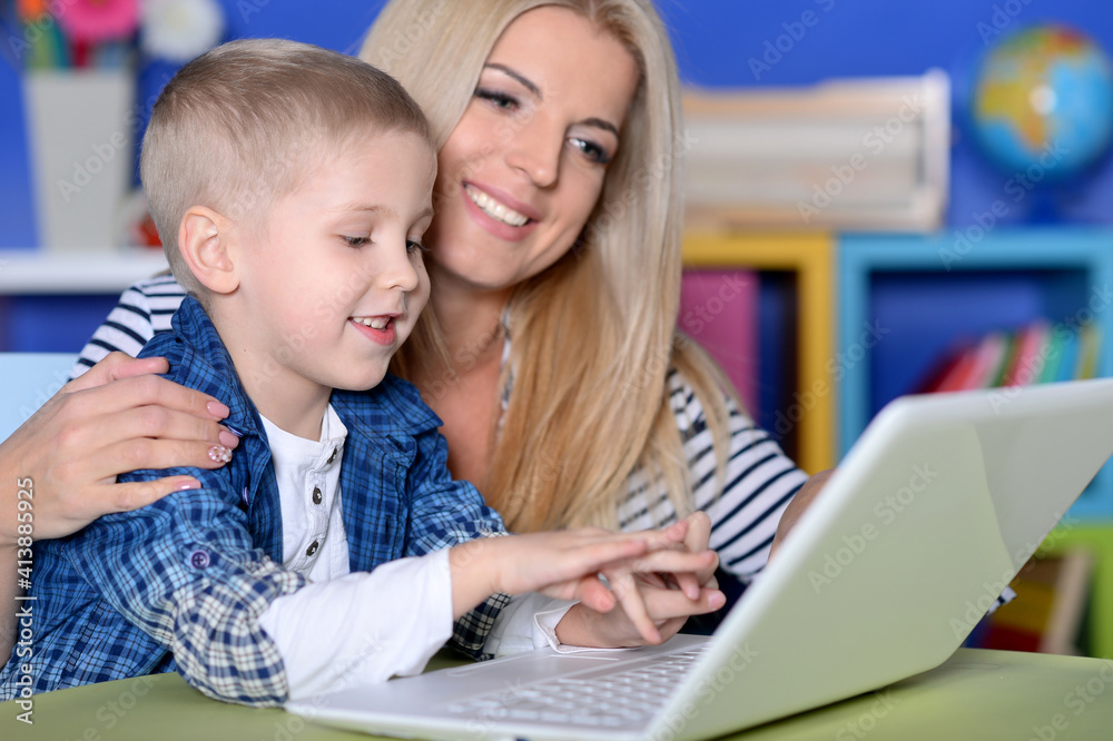 mother and son using modern laptop mother and son using modern laptop