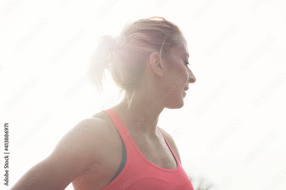 Low angle view of confident athlete looking away while standing against sky Low angle view of confident athlete looking away while standing against sky
