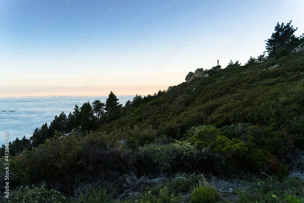 Distant view of woman standing on top of mountain Distant view of woman standing on top of mountain