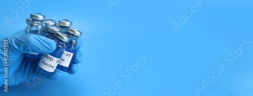 Ampoules of coronavirus vaccine injection in the hand of health worker. Copy space for text. Horizontal banner