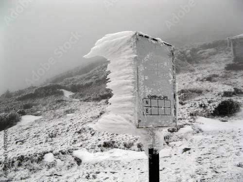frozen mountain information sign on a foggy morning © ovidiu