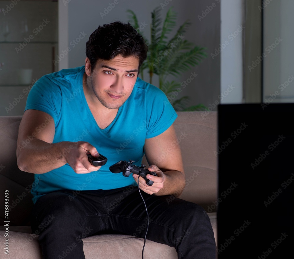 Young man playing computer games late at night Young man playing computer games late at night