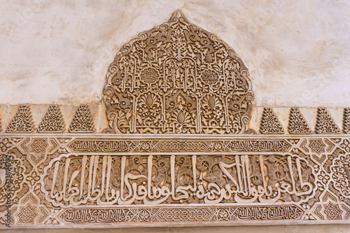 close up view of detailed carving and Arabic calligraphy work in the Alhambra