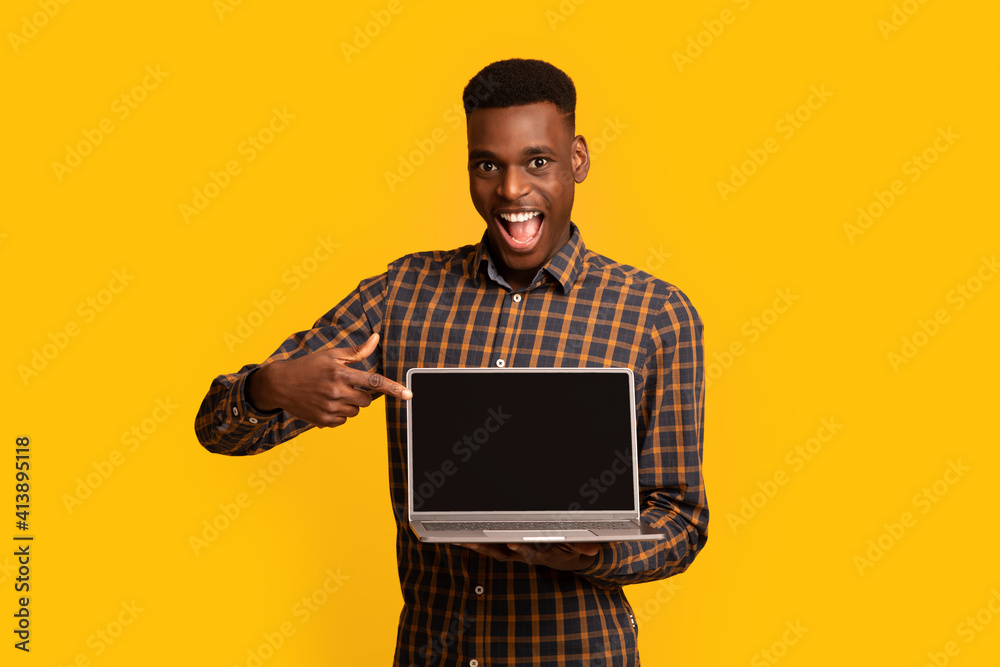 Check This Website. African Guy Pointing At Laptop Computer With Black Screen
