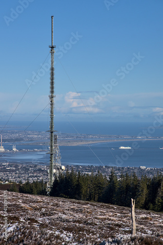 Beautiful view of Three Rock TV transmitter antennas viewed from Fairy Castle (Two Rock Mountain), Dublin Mountains, Ireland. Single cellular tower in fir fores. Vertical view. Dublin Bay aerial