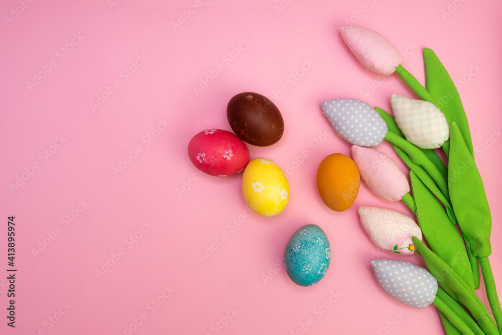 Easter background with painted eggs and colorful tulips. Top view with copy space