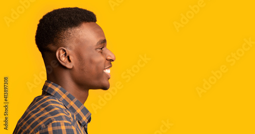 Profile Shot Of Cheerful Young African American Guy Looking At Copy Space © Prostock-studio