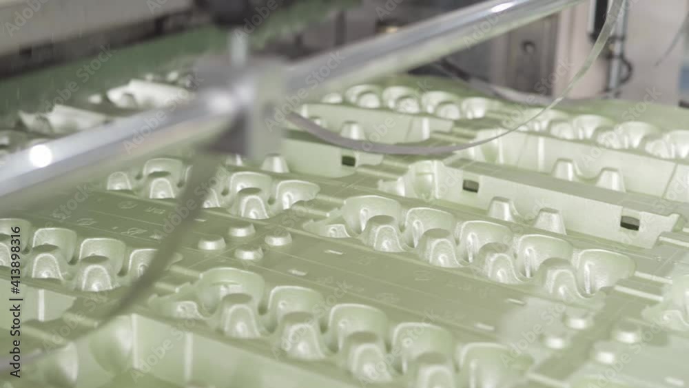 Disposable food package ware manufacturing plant, eggs containers production line. Work on high performance automated machinery. Machines create packing for eggs for sale in supermarket Disposable food package ware manufacturing plant, eggs containers production line. Work on high performance automated machinery. Machines create packing for eggs for sale in supermarket