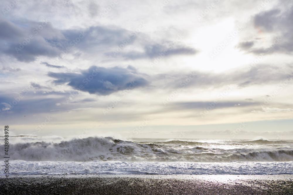 View of waves on shore against cloudy sky View of waves on shore against cloudy sky