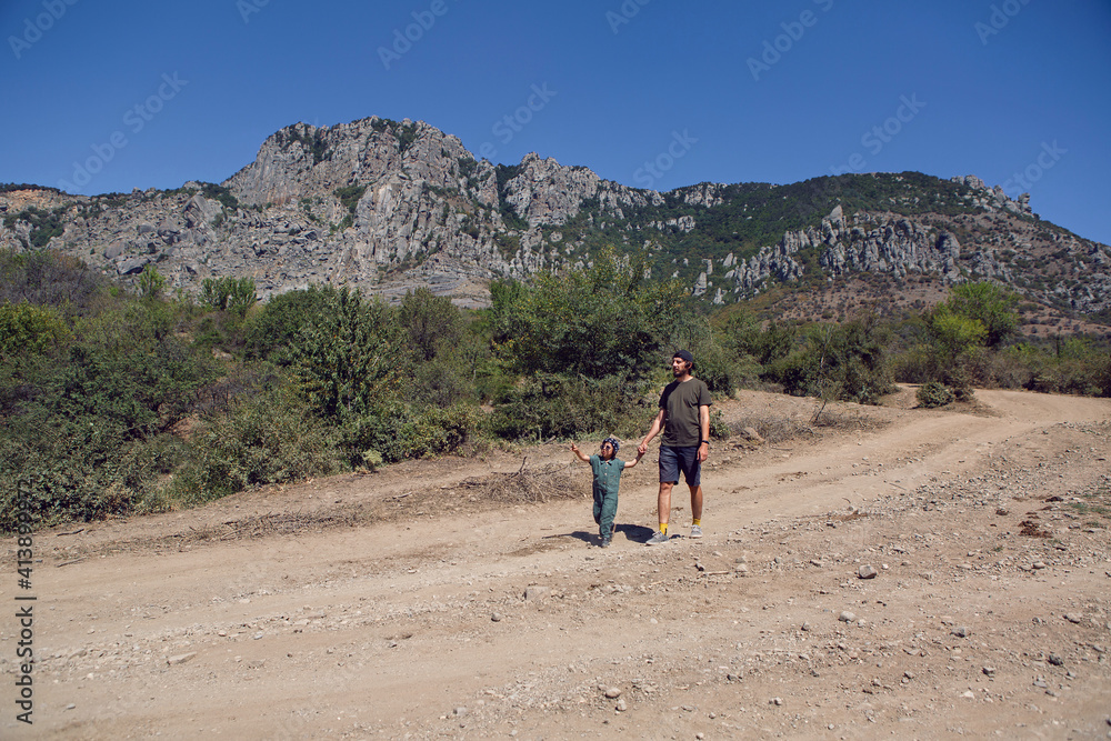 boy child travels with his father through the mountains in the summer in the Crimea