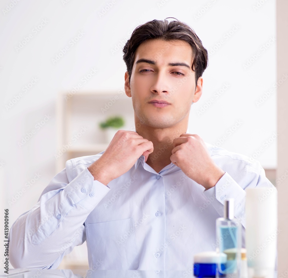 Man is getting dressed up for work in bathroom Man is getting dressed up for work in bathroom