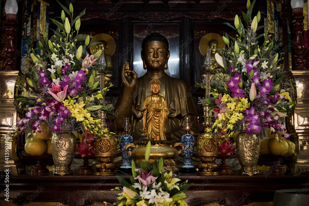 Buddha statues by flowers in temple