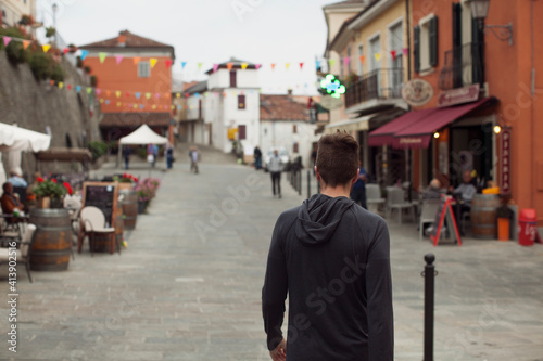 Rear view of man standing on footpath in market at town photo