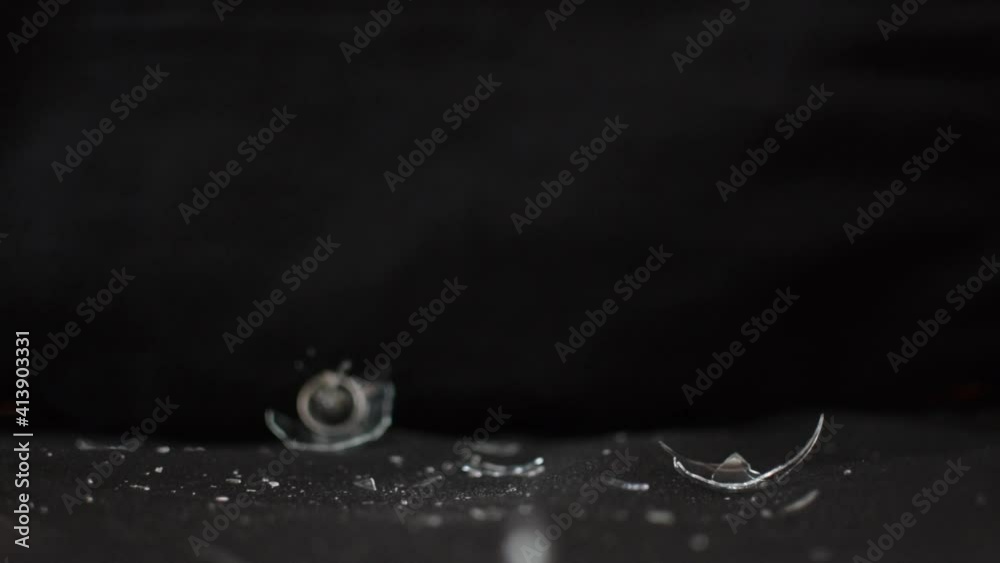 Un martillo golpeando una bombilla y rompiéndola en pedazos sobre fondo negro