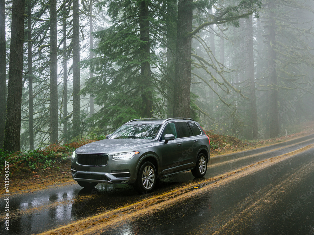 SUV automobile driving through foggy and rainy forest road SUV automobile driving through foggy and rainy forest road